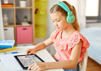 education, e-learning and school concept - happy student girl in headphones with teacher on tablet computer having online lesson at home desk