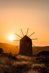 Orange colours of sunset time, one old windmill in the mountains