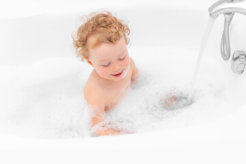 A child girl bathes in a bath.