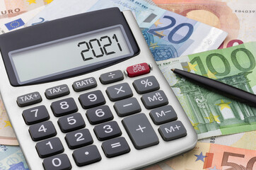 Calculator with money and a pen - 2021