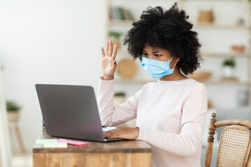 Fototapeta na wymiar Sad African Girl In Mask Sitting At Laptop At Home