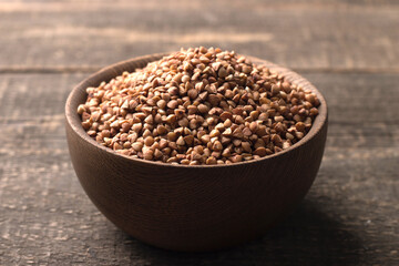 Buckwheat groats on wooden background. Healthy cereal concept.  