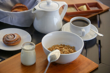 Continental hotel breakfast served at the table. Cereals, pastries, coffee, yoghurt, jams and spreads.