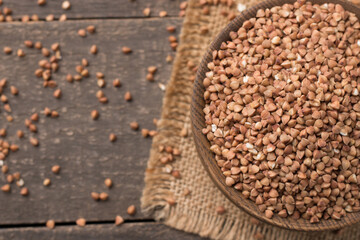 Buckwheat groats on wooden background. Healthy cereal concept.  