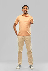 Fototapeta premium choice and people concept - smiling young indian man pointing fingers at you over grey background