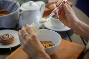 Continental hotel breakfast served at the table. Cereals, pastries, coffee, yoghurt, jams and spreads.