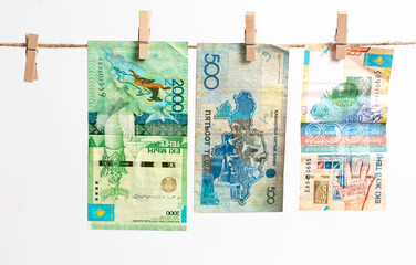 Kazakh tenge hang on a rope on a white background.