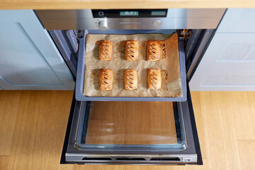 food cooking, culinary and pastry concept - baking tray with jam pies in oven at home kitchen