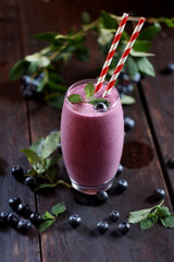 Glass of blueberry smoothie on wooden background. Selective focus
