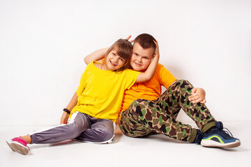 Two smiling children - a boy and a girl in the studio on a white background