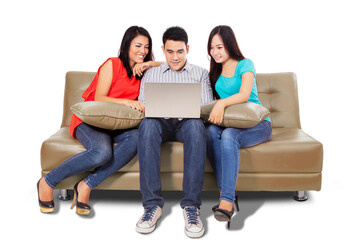 Group of happy young people using laptop on studio