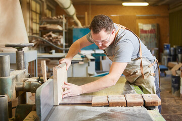 Tischler schneidet Holz mit Tischsäge in Tischlerei