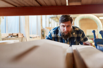 Schreiner holt Holz als Bauholz aus dem Lager
