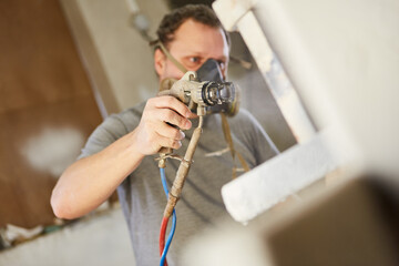 Lackierer mit und Atemschutz und Sprühpistole