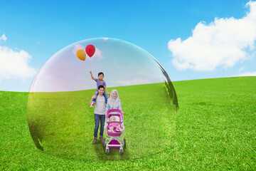 Muslim family walking at park in protective bubble