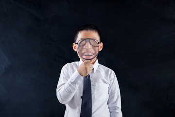 Preteen boy holds magnifier front of his mouth