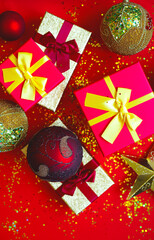 gift boxes with bows and Christmas toys on a red-gold background