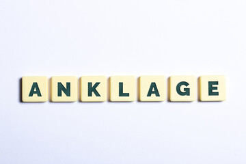 Das Wort Anklage in Buchstaben auf weißem Hintergrund