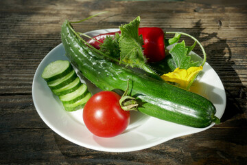 Fresh vegetables in a white plate on a wooden background