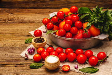 Assorted ripe multicolored tomatoes. Young garlic, fresh basil leaves, salt, spices