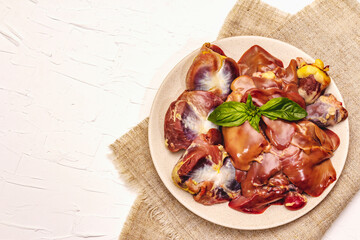 Fresh raw chicken offal: heart, liver, stomach with dry spices, sea salt, chili pepper on white...