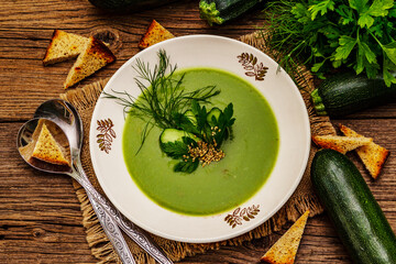 Green zucchini cream soup. Healthy vegan (vegetarian) food, crispy toast, sesame seeds, whole ripe fruits, fresh greens