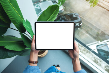 Top view mockup image of a woman holding digital tablet with blank white desktop screen