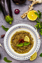 Eggplant dip baba ganoush (mutabbal) or mezze with ripe vegetables and fresh herbs