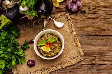 Eggplant dip baba ganoush (mutabbal) or mezze with ripe vegetables and fresh herbs