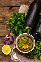 Eggplant dip baba ganoush (mutabbal) or mezze with ripe vegetables and fresh herbs