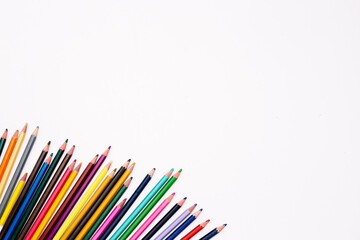 Colored pencils isolated on white paper with place for text. Banner on the artistic theme of the creative development and education of preschoolers, schoolchildren and adults. Art stationery