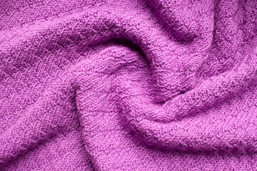 Fototapeta na wymiar Pleats on fabric, knitted material of purple color, folds