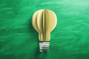 Yellow light bulb made from paper on blackboard  background.