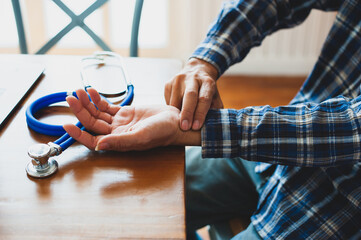 Young man measured his pulse with his hand.