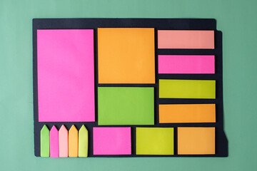 Bright geometric colored background from sticky notes on a green background. Minimalistic color art free space for text. Fantasies and dreams in the office and school.
