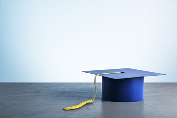 Blue graduation cap on wooden table