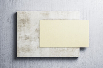 Empty yellow poster hanging on concrete wall.