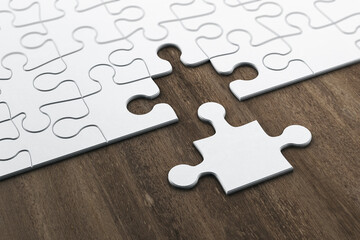 Plain white jigsaw puzzle on wooden table.