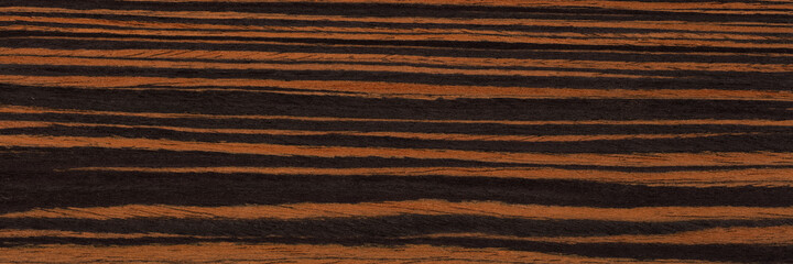 Natural ebony veneer background in elegant brown colors. Natural wood texture, pattern of a long veneer sheet, plank.