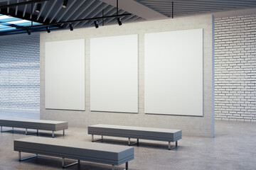 Gallery interior room with three empty posters on gray wal