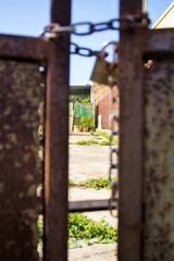evocative image of part of rusty gate with chain and lock