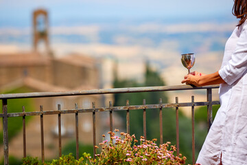 Holidays in Tuscany. Middle aged woman wearing a white dress watches the landscape of Tuscany from...