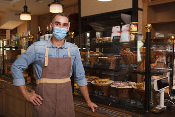 Male baker wearing medical face mask working at his bakery store during coronavirus quarantine - Powered by Adobe