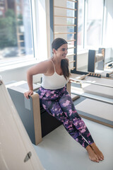 Plus-sized woman doing exercises in a gym