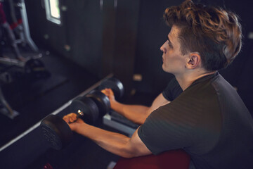 young guy bodybuilder works out in the gym    