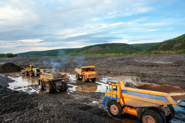 Gold mining industry. Loading and transportation of gold-bearing mountain soil by mining dump trucks in order to further extract natural gold from this mass. Eastern Siberia