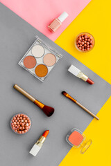 Lauout of multicolor cosmetics - powder concealer eye shadow lipstic. Top view