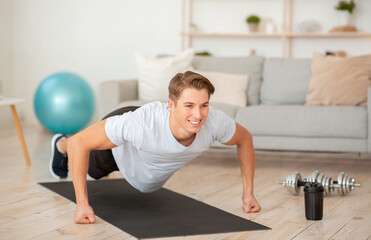 Quarantine sport. Muscular guy doing push-up exercises on fists
