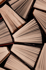 Open multi-colored old books stand on a bookshelf in the home library