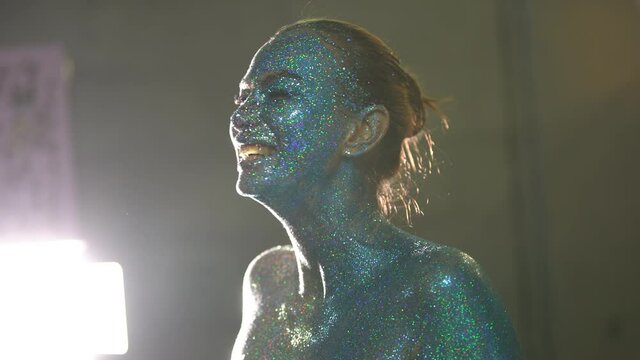 Visagiste put glitter on woman face backstage video
